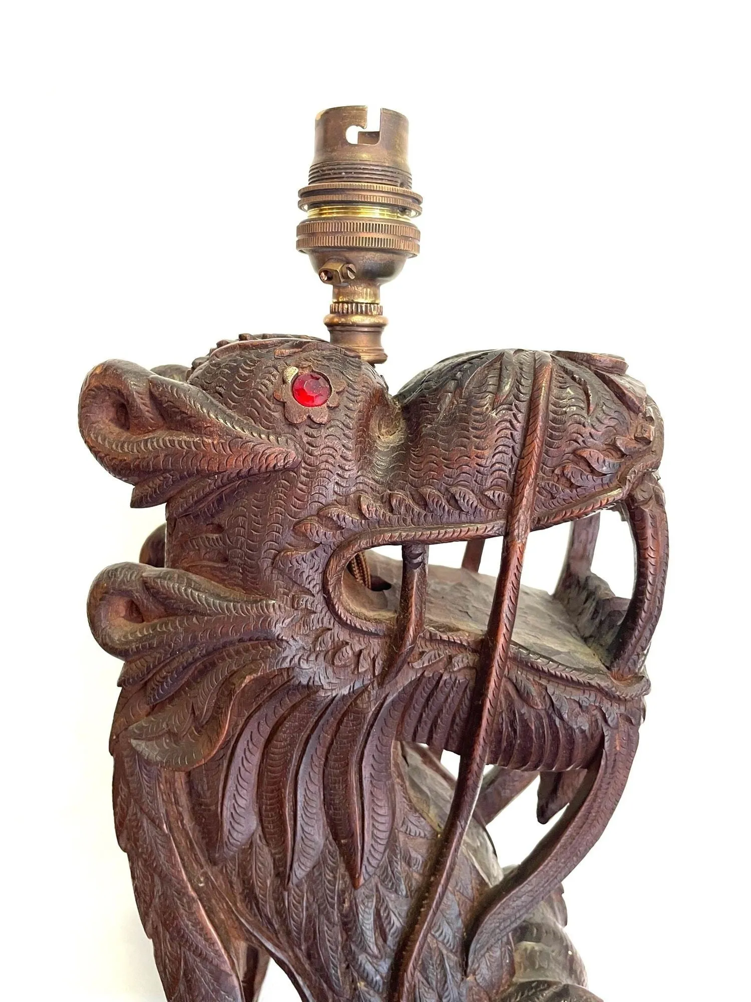 A pair of intricately carved Burmese dragon lamps each mounted on carved wooden base.